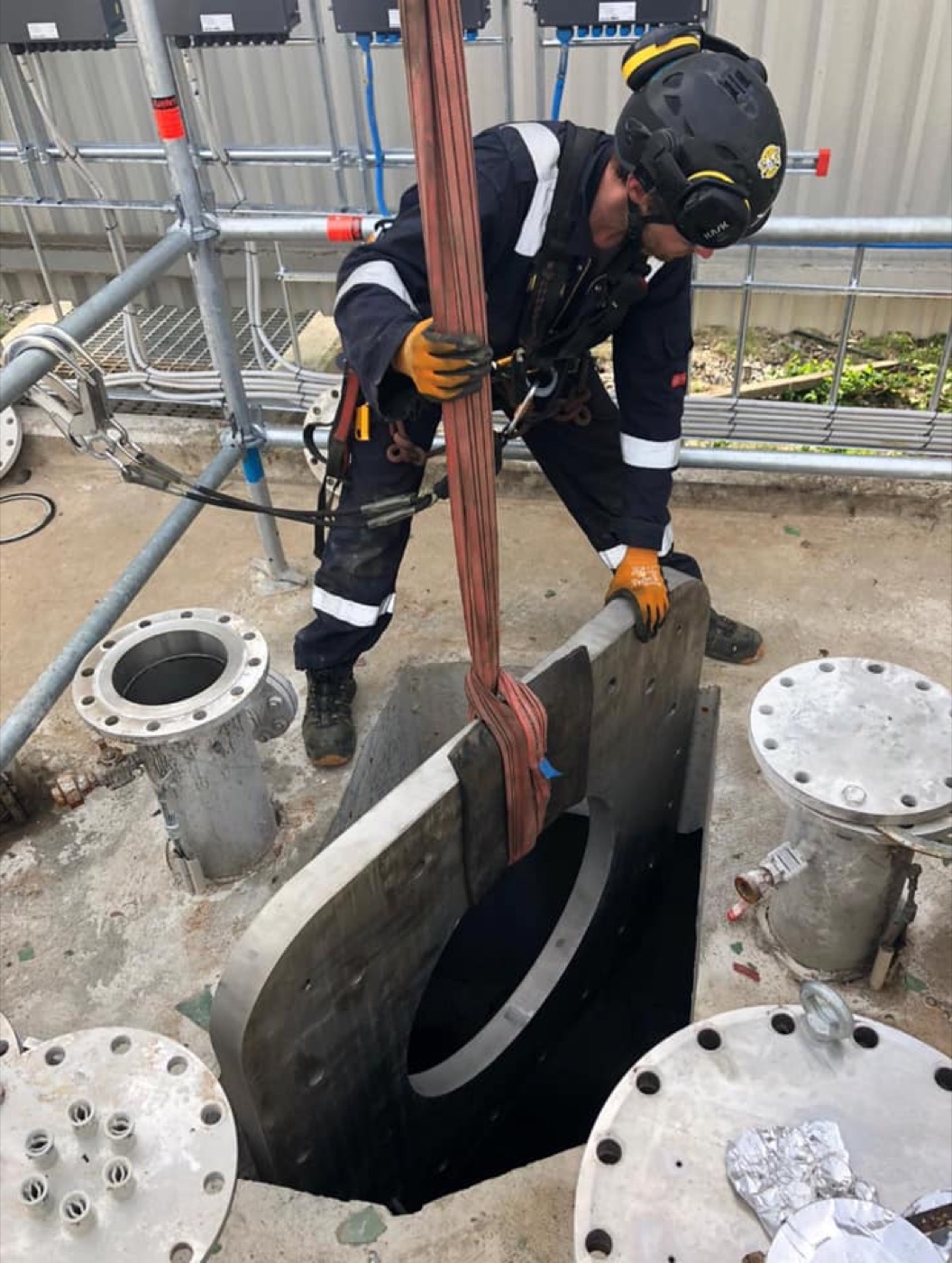 Worker entering a confined-space tank hatch